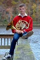 High school senior holding French horn during studio session at Gilbert Run Park