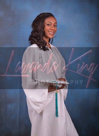 High school graduate with wearing grown and holding cap at Lawanda King Photography studio