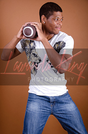 Football -themed senior pictures with brown background at Lawanda King Photography studio