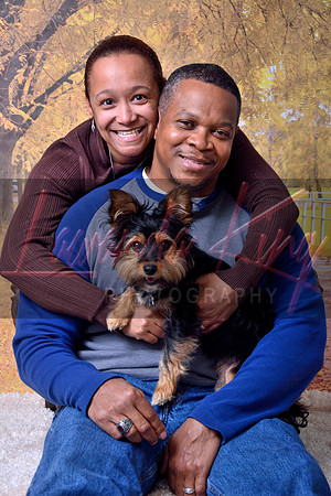 Couple posing with Yorkie with fall foliage background at Lawanda King Photography studio